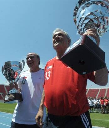 Lobos (E) e Piñera erguem taças conquistadas após amistoso em Santiago
