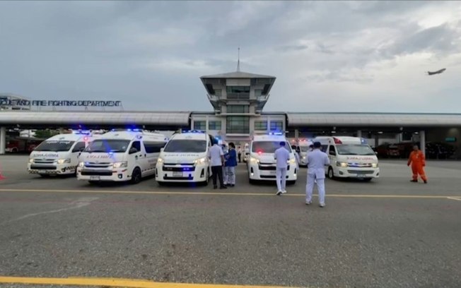 Equipe médica se aproxima da aeronave da Singapore Airlines que fez um pouso de emergência no aeroporto internacional Suvarnabhumi, em Bangcoc