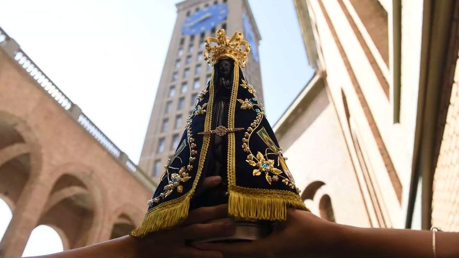Imagem de Nossa Senhora Aparecida com a torre da basílica ao fundo Imagem de Nossa Senhora Aparecida com a torre da basílica ao fundo