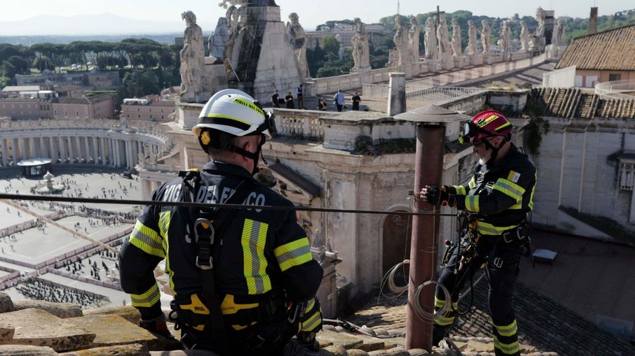 Funcionários do Vaticano instalam a chaminé no teto da Capela Sistina