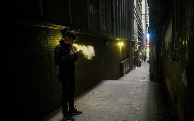 (Arquivo) Uma pessoa fuma um cigarro eletrônico em um beco em Hong Kong