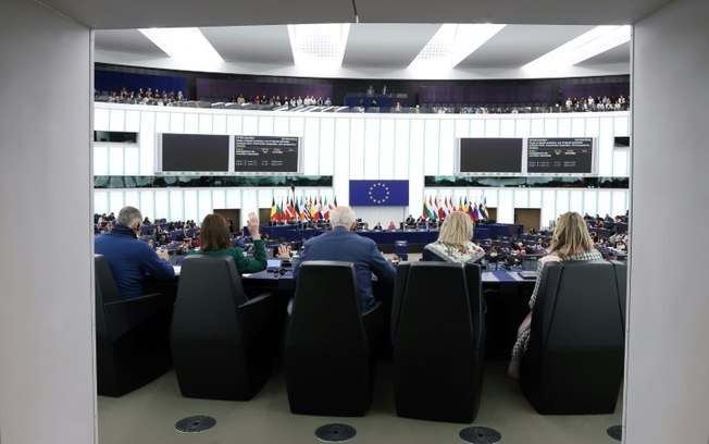 Membros do Parlamento Europeu levantam as mãos para votar durante uma sessão plenária no Parlamento Europeu em Estrasburgo, leste da França, em 24 de abril de 2024