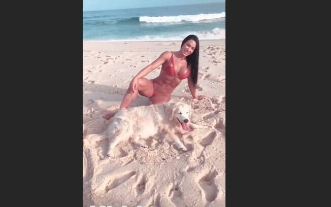 Gracyanne Barbosa sensualiza na praia com cachorro