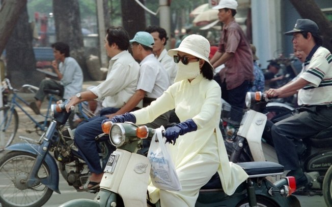 Mulher usa máscara em Ho Chi Minh em 21 de outubro de 1995