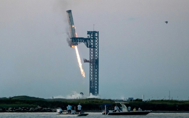 O propulsor SuperHeavy retorna à base da SpaceX no Texas, em 13 de outubro de 2024