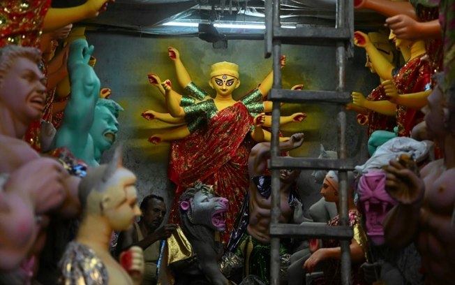 Artesão se prepara para trabalhar em um ídolo de argila da deusa hindu Durga, antes do festival Durga Puya em Calcutá, em 27 de setembro de 2024