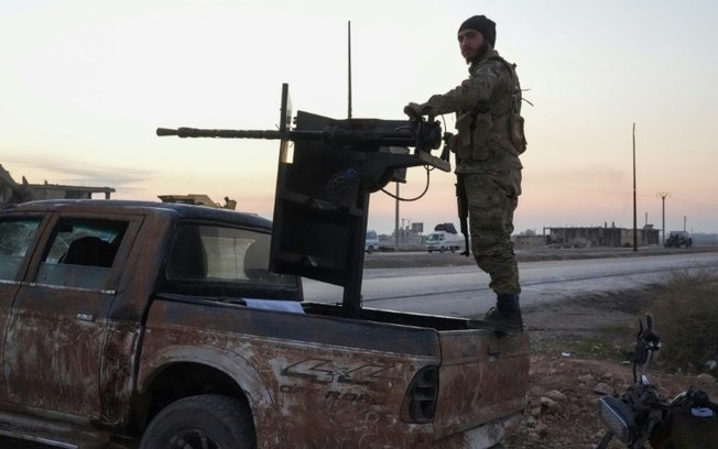 Combatente insurgente em caminhonete equipada com uma arma na rodovia entre Aleppo e Raqqa, norte da Síria