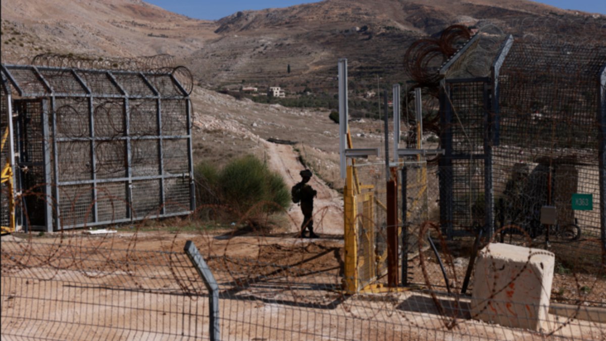 Um soldado israelita monta guarda na vedação da zona tampão que separa os Montes Golã, anexados por Israel, do resto da Síria, perto da aldeia drusa de Majdal Shams, a 9 de dezembro de 2024.