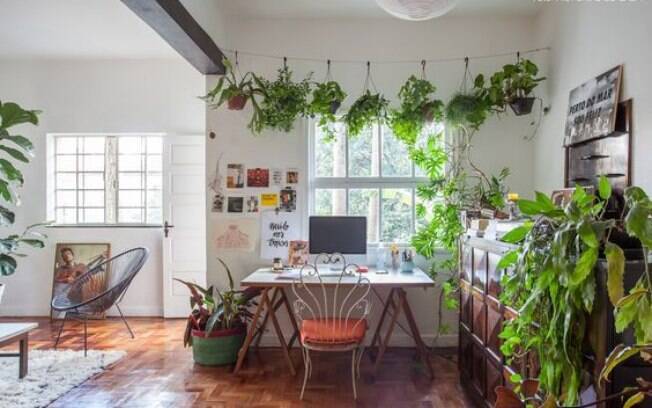 Uma simples mesa com cavalete, bem localizada perto de uma janela, cria um espaço de home office aconchegante, com muita luz natural, e que ainda é permeado por plantas. 
