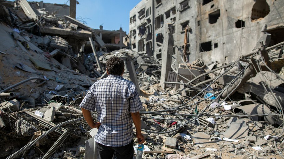 Um homem palestino de Gaza em frente à sua casa destruída na área de Al Remal, em Gaza