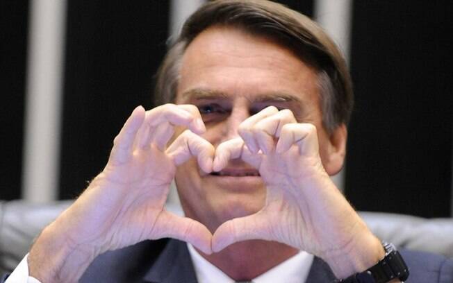 Bolsonaro faz símbolo de coração com a mão na Câmara dos Deputados.