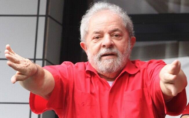 O ex-presidente Lula acena para simpatizantes da sacada de seu apartamento, no domingo