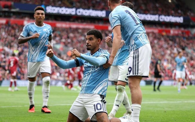 McAtee (de azul), do Nottingham, chega primeiro na disputa com Victor Munoz Liverpool McAtee (de azul), do Nottingham, chega primeiro na disputa com Victor Munoz Liverpool