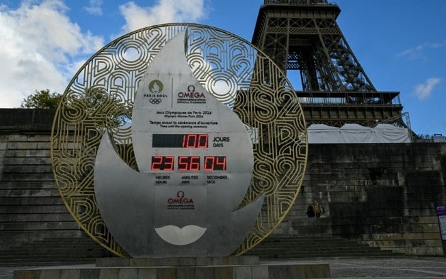 Relógio marcando a contagem regressiva para a abertura dos Jogos Olímpicos de Paris, ao lado da Torre Eiffel, em 16 de abril de 2024