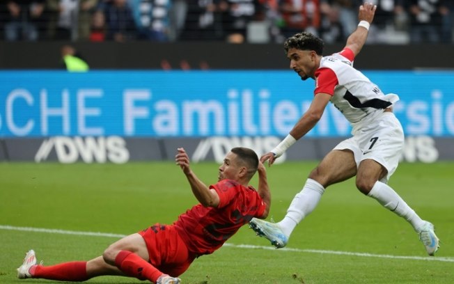 O atacante egípcio do Eintracht Frankfurt, Omar Marmoush (à direita), chuta para fazer 1 a 1 no jogo contra o  Bayern de Munique, em Frankfurt, em 6 de outubro de 2024