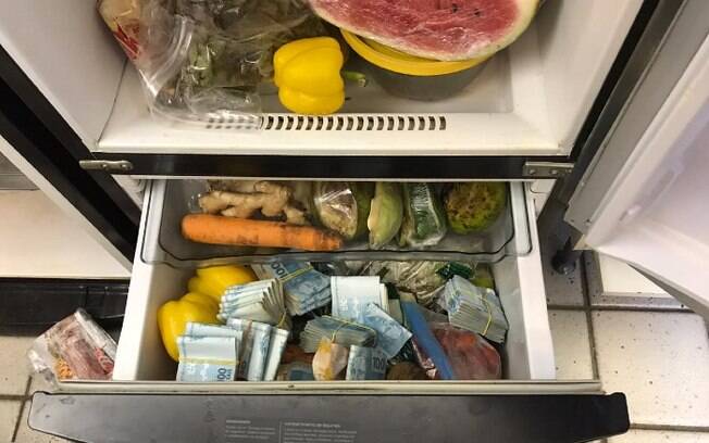 Na casa de um dos suspeitos, foram encontrados maços de dinheiro escondidos dentro de uma geladeira
