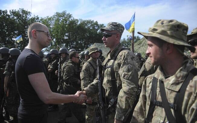 Premiê ucraniano, Arseniy Yatsenyuk (E), cumprimenta soldado ao inspecionar tropas em Slovyansk, leste da Ucrânia (16/07). Foto: AP
