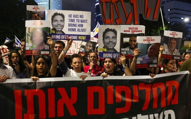 Milhares de pessoas seguram fotos de reféns em manifestação em Tel Aviv em 4 de maio de 2024