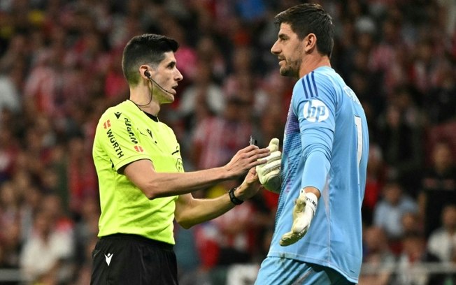 Árbitro Mateo Busquets conversa com o goleiro Thibaut Courtois durante o empate entre Atlético de Madrid e Real Madrid em 1 a 1 neste domingo, pelo Campeonato Espanhol