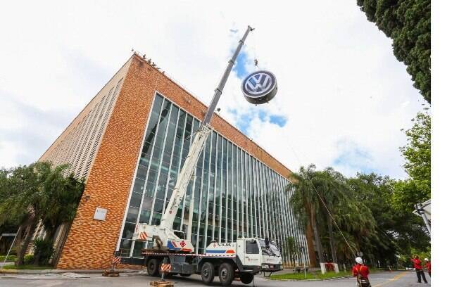 Guindastes transportam o novo logotipo, que é visível para quem passa pelo quilômetro 23 da Rodovia Anchieta