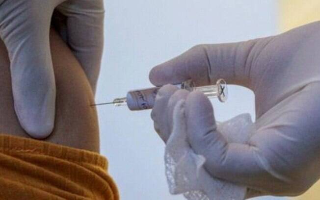 Voluntária recebendo dose da vacina