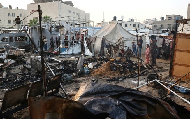 Palestinos revisam danos em campo de deslocados dentro do Hospital dos Mártires de Al Aqsa, em Deir al Balah, centro da Faixa de Gaza, em 14 de outubro de 2024