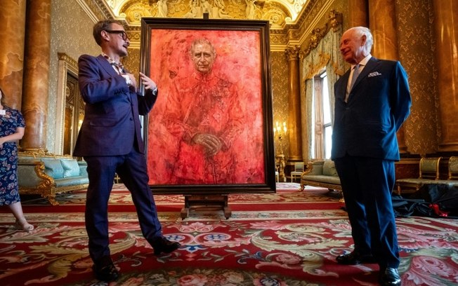 O rei Charles III (D) do Reino Unido ao lado do artista Jonathan Yeo durante a revelação do retrato oficial do monarca no Palácio de Buckingham, em Londres, em 14 de maio de 2024