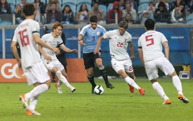 Suárez tenta superar marcação durante jogo entre Uruguai e Japão, em Porto Alegre, pela Copa América