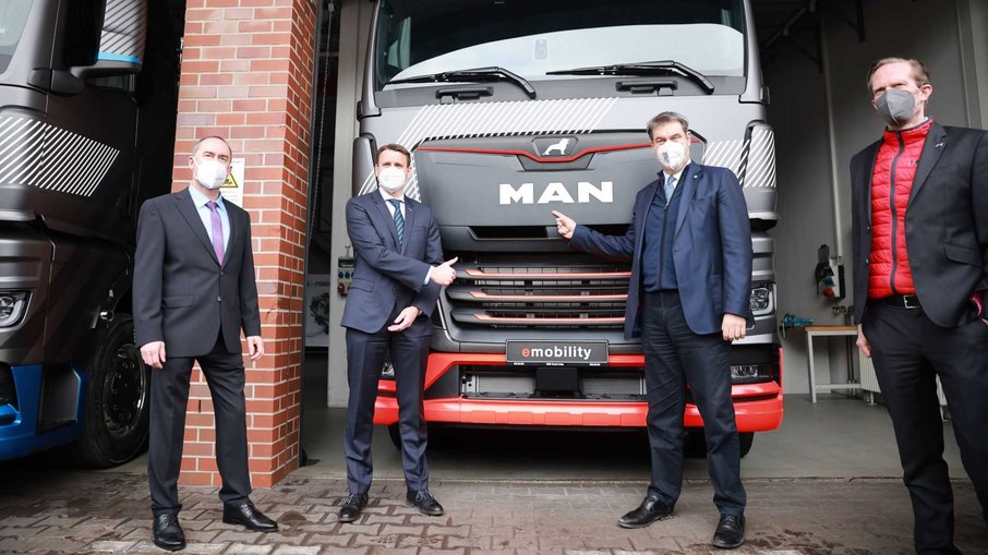 Executivos da MAN Truck%Bus na frente do caminhão elétrico que dá mais um passo rumo à eletrificação da linha