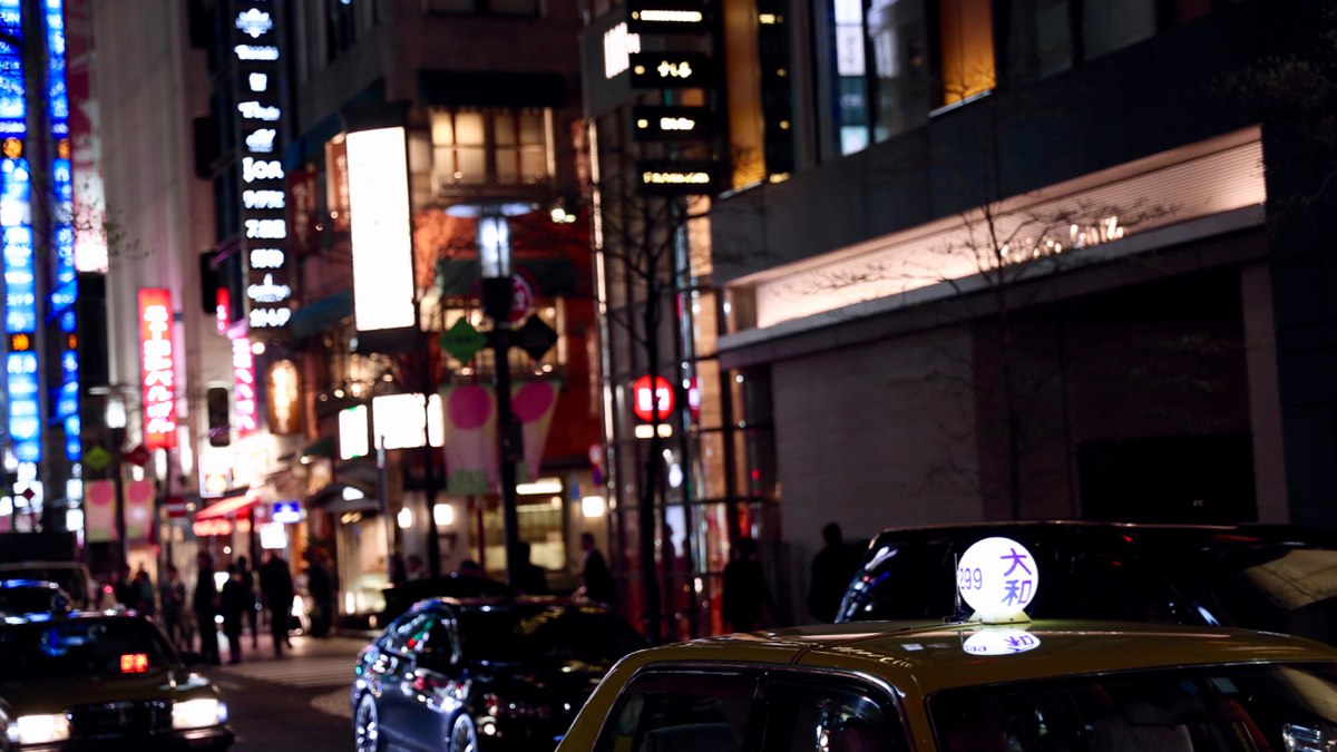 Carros transitam por ruas de cidade japonesa durante a noite