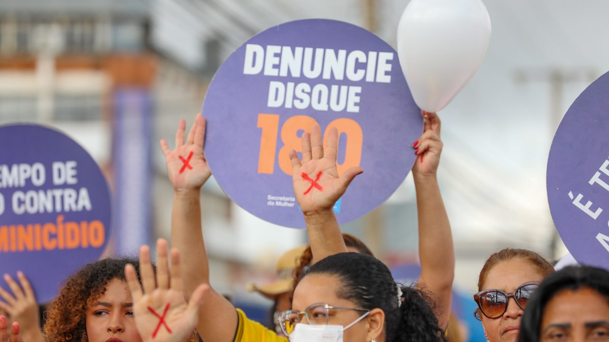 Mulheres caminham em Ceilândia, no Distrito Federal, em protesto contra o feminicídio