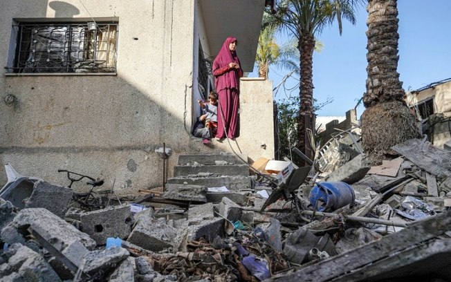 Palestina observa os danos em sua casa após bombardeio israelense em Nusseirat, centro de Gaza