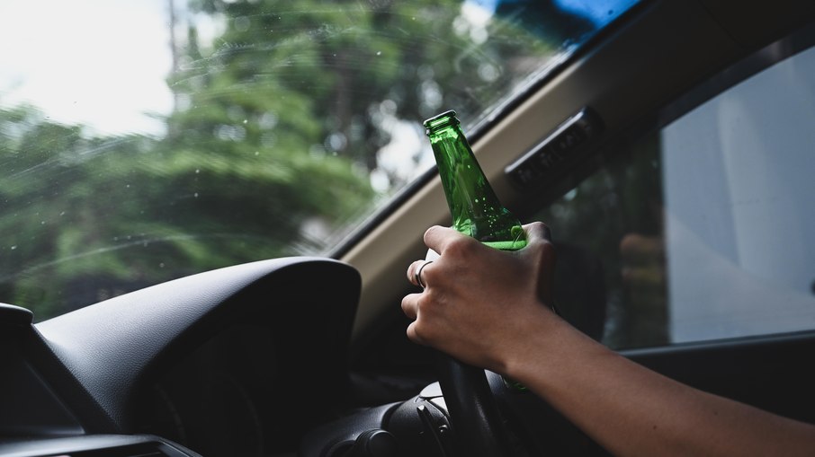 Motorista com bebida ao volante Motorista com bebida ao volante
