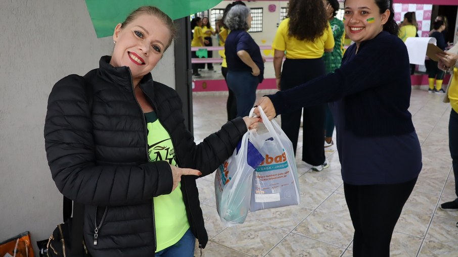 Participante entrega ração durante Aulão da Copa