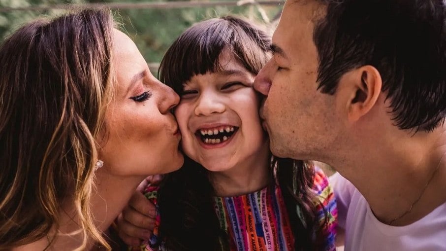 Thamirys Nunes, com a filha, uma criança trans, e o marido
