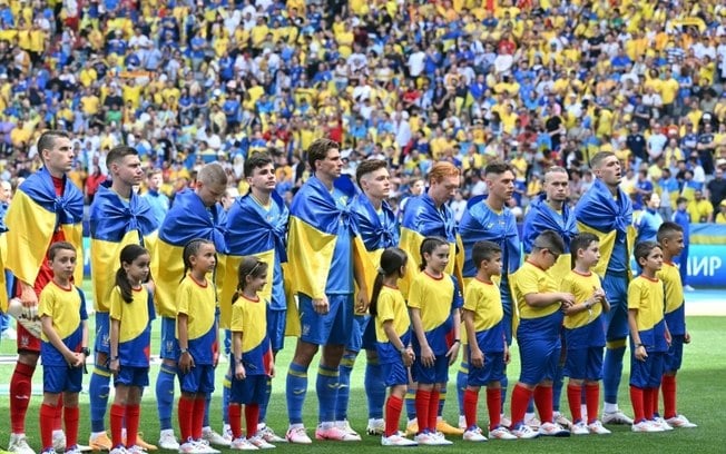 Jogadores da Ucrânia durante a execução do hino nacional antes do jogo contra a Romênia.
