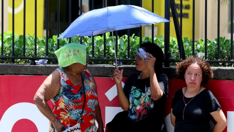 Candidatos se protegem do forte calor enquanto aguardam abertura dos portões para o segundo dia provas do Enem 2023, na Universidade Veiga de Almeida, na Tijuca, zona norte da cidade