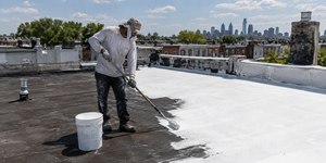 Cidade pinta de branco telhados de casas e calor cai pela metade