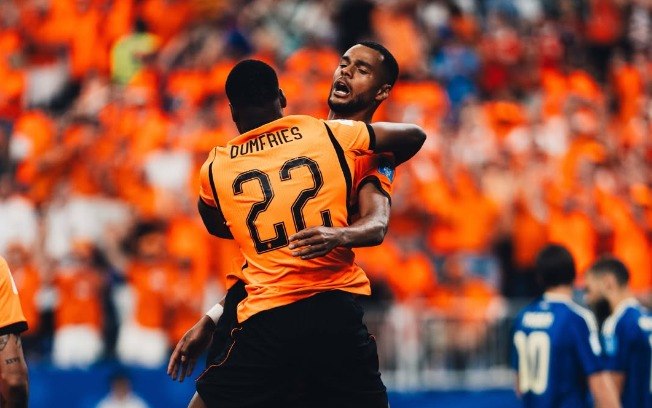 Gakpo e Dumfries se abraçam após gol da Holanda contra a Suécia