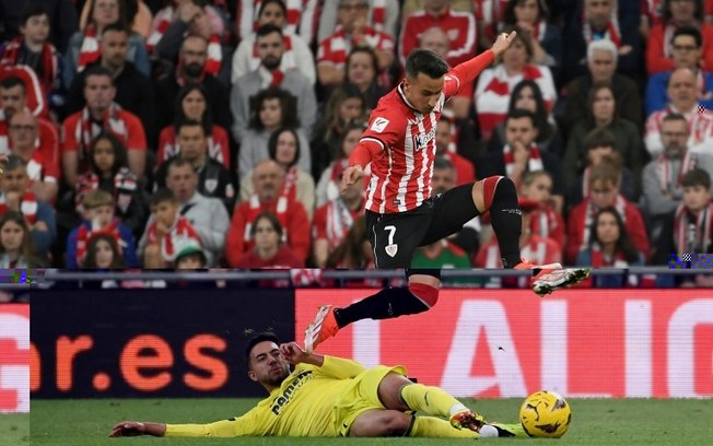 O atacante do Athletic Bilbao, Álex Berenguer, evita o desarme do jogador do Villarreal, Ilias Akhomach, durante o jogo de LaLiga entre as duas equipes, em San Mamés (Bilbao), em 14 de abril de 2024