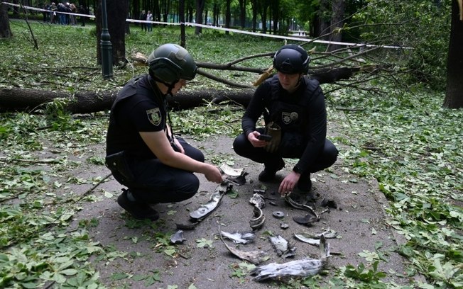 Policiais ucranianos examinam fragmentos de um míssil em um parque em Kharkov, Ucrânia, em 19 de maio de 2024