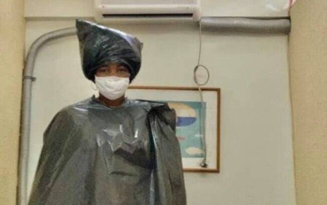 A esteticista Cristiane Boneta vestida com sacos plásticos antes de atendimento odontológico