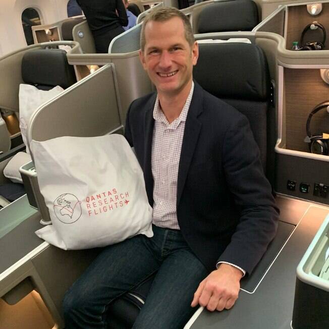 Ben Mutzabaugh foi convidado, junto a outros jornalistas e clientes da Qantas, a viajar no voo mais longo do mundo Ben sentado em seu lugar com uma almofada da Qantas sobre o colo