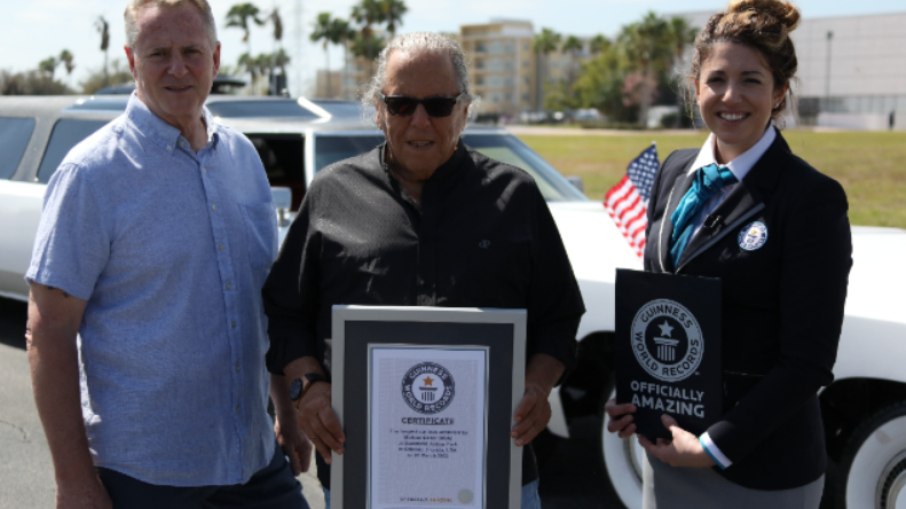 Michael Manning, dono do maior carro do mundo, ao lado de seu certificado Guinnes Records 