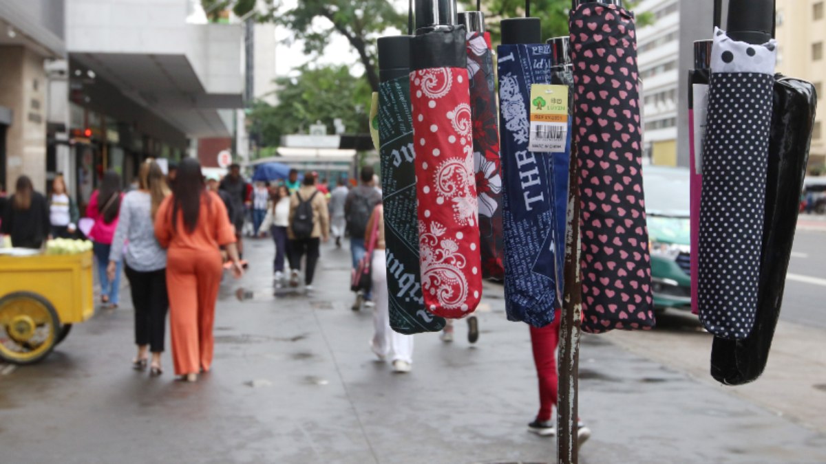 Pedestres na Avenida Paulista durante a chegada da frente fria