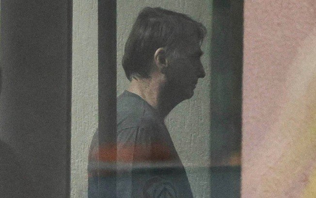 O ex-presidente Jair Bolsonaro, nor portão da sede da PF, neste domingo (23) 