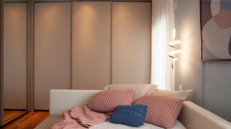 Nos detalhes, almofadas e manta em tricô, iluminação espiral em LED e o quadro que acompanha as tonalidades eleitas para o décor do dormitório