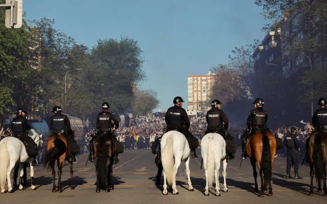 Policiais espanhóis patrulham o exterior do Estádio Santiago Bernabéu, antes do início da partida entre Real Madrid e Manchester City, em 9 de abril de 2024