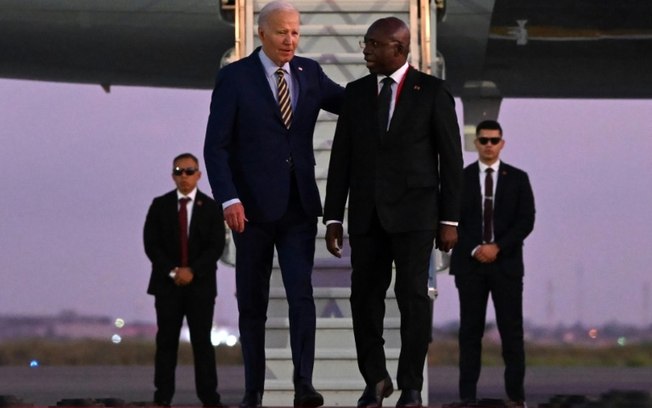 O presidente americano, Joe Biden (E), conversa com o ministro angolano das Relações Exteriores, Tete Antonio, após aterrissar no aeroporto internacional de Luanda, em 2 de dezembro de 2024