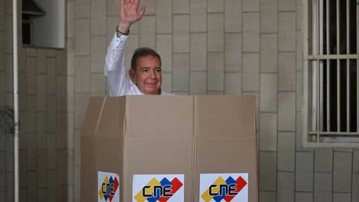 Opositor Edmundo González Urrutia acena enquanto vota na escola Santo Tomas de Villanueva, em Caracas, durante a eleição presidencial 